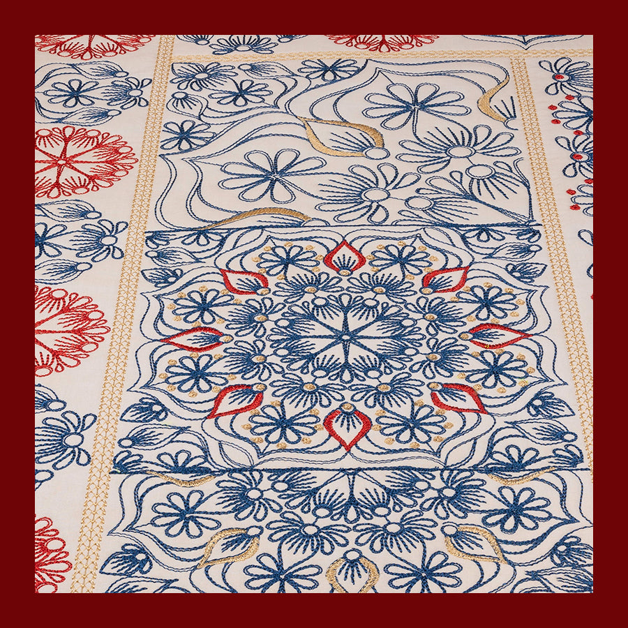 A quilt block with a geometric pattern featuring a combination of solid and quilted sections, predominantly in blue, red, and white.