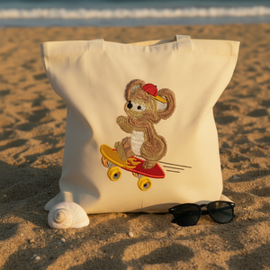 Tote bag with a teddy bear on a skateboard design held by hands on sand