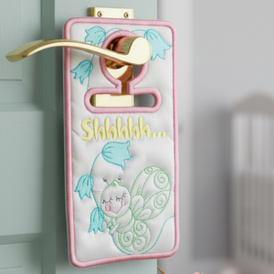 Decorative door handle cover with embroidery and text on a door