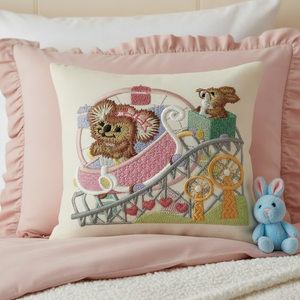 Embroidered pillow with teddy bear design on pink pillowcase, surrounded by stuffed toys.