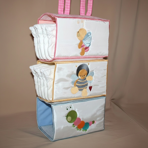 Stack of baby diaper bags with cartoon designs on a beige background