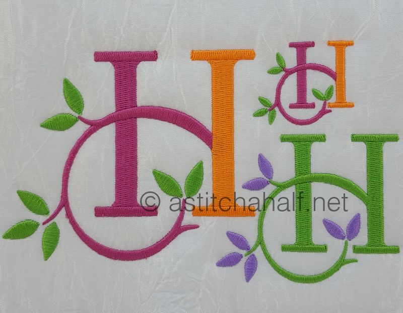 Embroidered monograms 'H' in various colors with leaf and flower designs on a white background.