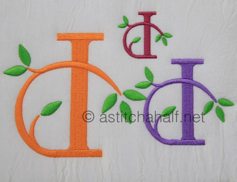 Embroidered letters 'D' in various colors with leaves on a textured white background.