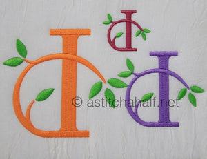 Embroidered letters 'D' in various colors with leaves on a textured white background.