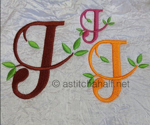 Three embroidered letters 'J' in different colors on a textured fabric background.