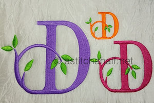 Embroidered letter 'D' with green leaves on a textured background