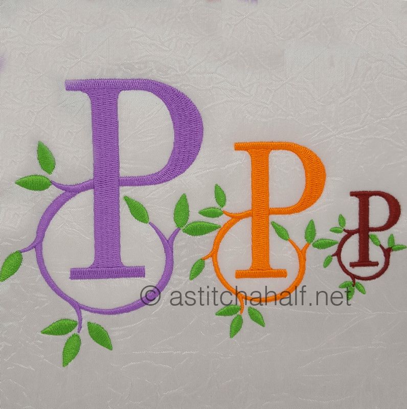 Three embroidered letters 'P' in different colors with green leaves on a textured white background.