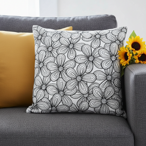 Decorative pillow with floral pattern on a gray couch with yellow pillow and sunflowers.