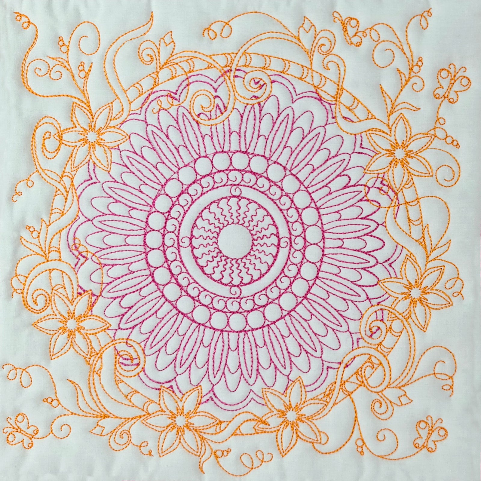 Decorative bedspread with mandala patterns on a bed in a bedroom setting.
