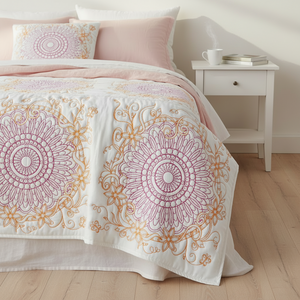 Decorative bedspread with mandala patterns on a bed in a bedroom setting.