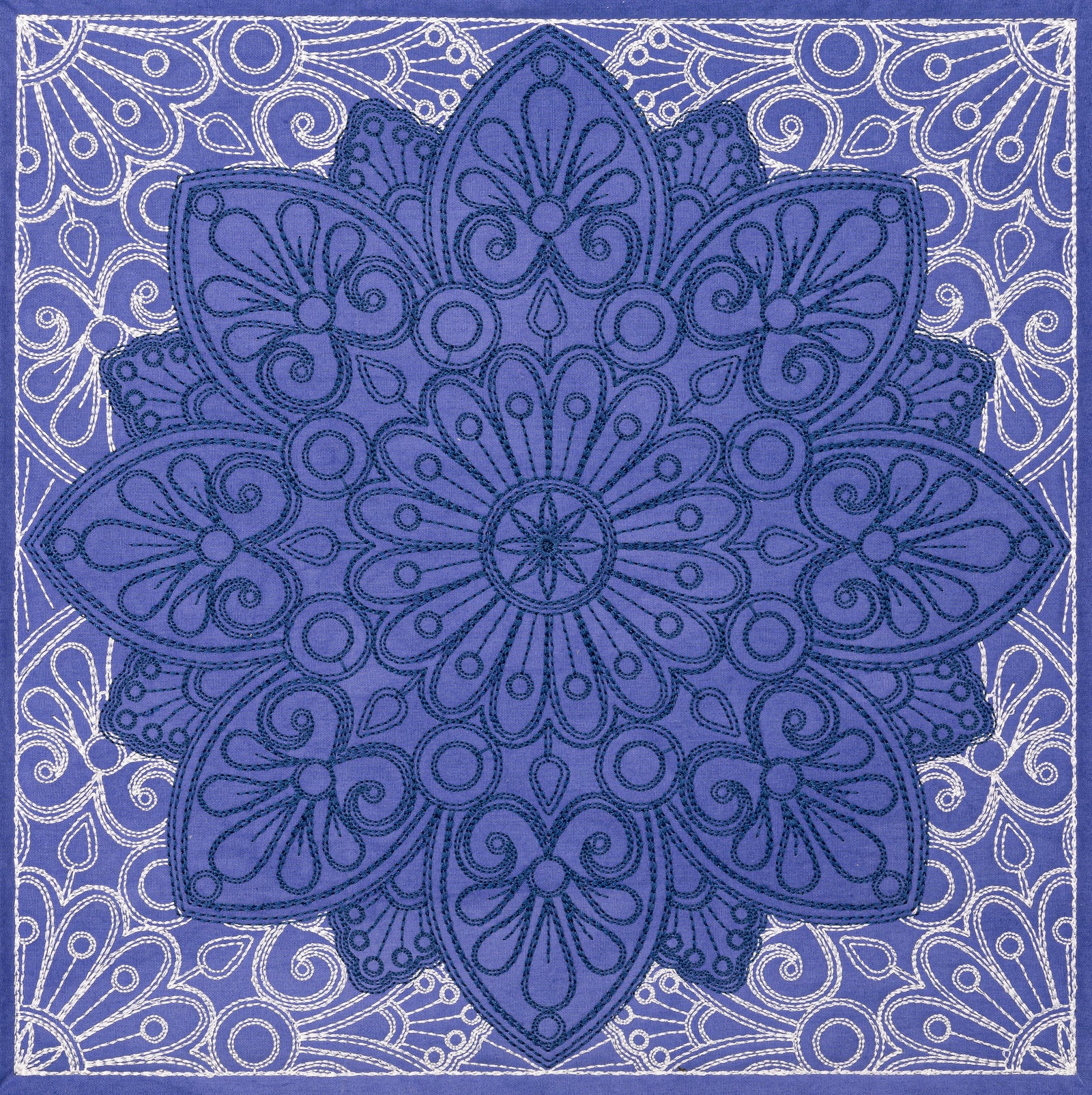 Blue patterned throw blanket on a bed in a bedroom setting