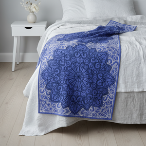 Blue patterned throw blanket on a bed in a bedroom setting