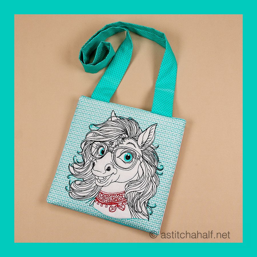 This embroidery design shows a cute pony with flowing hair, wearing turquoise glasses and an ornate collar. It's stitched in brown thread on light fabric with turquoise accents, creating a whimsical, bespectacled fantasy character. Perfect for a crossbody bag