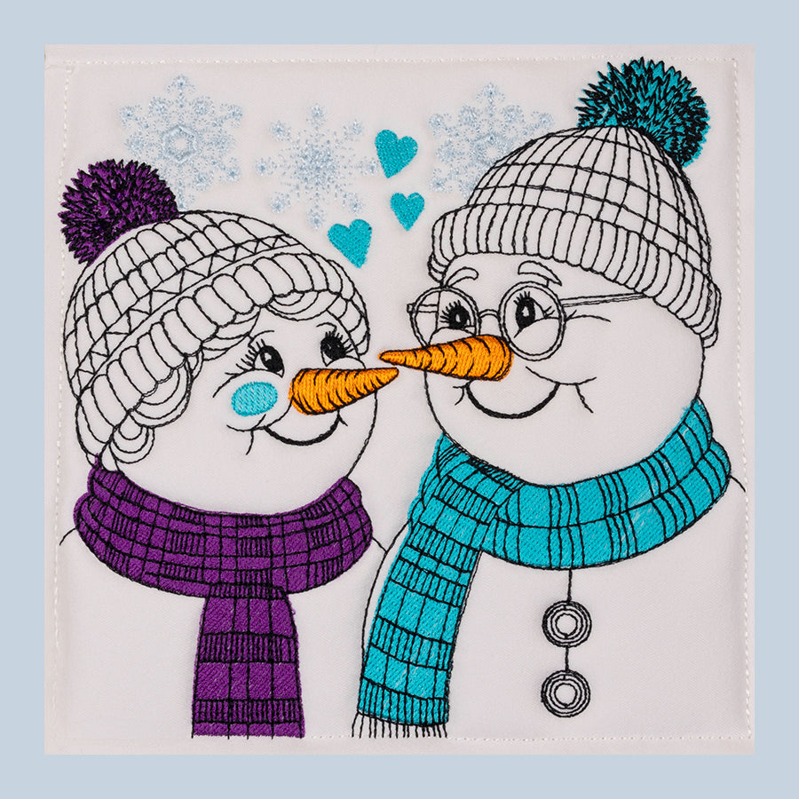 A digital embroidery design of two snowmen with hats and scarves, one in purple and one in blue, with hearts in the background.