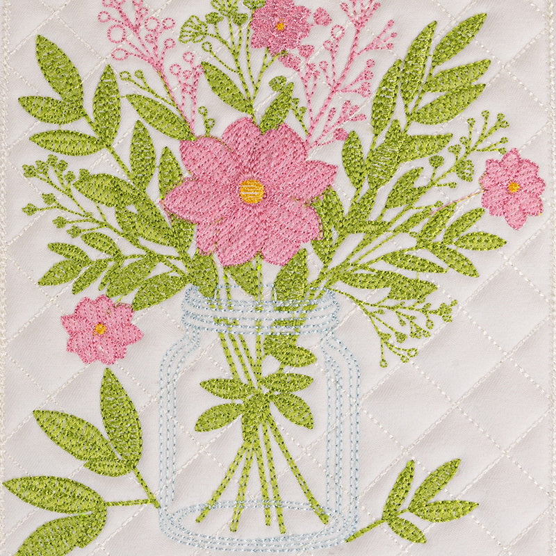 Embroidered floral design on fabric with a pair of scissors.