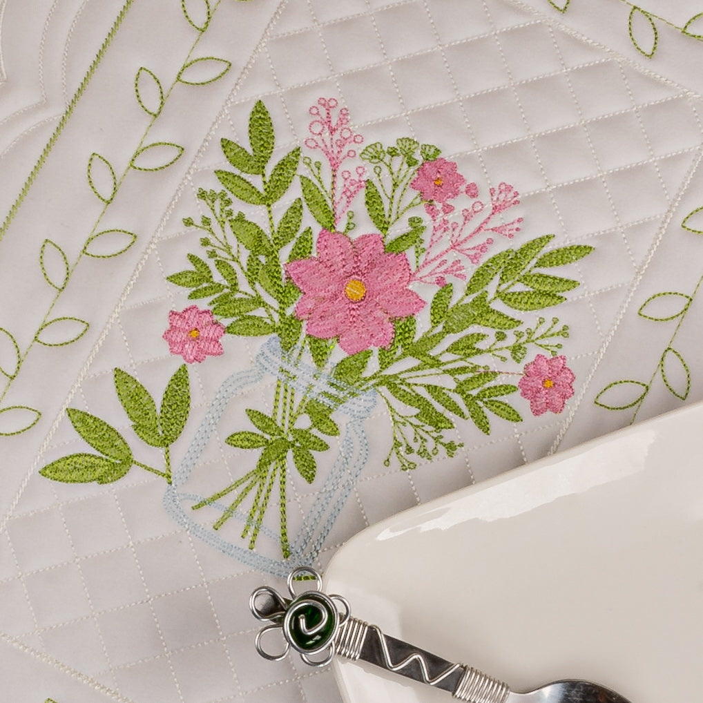 Embroidered floral design on fabric with a pair of scissors.