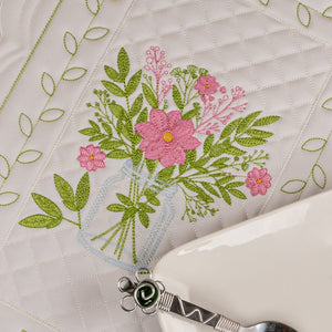 Embroidered floral design on fabric with a pair of scissors.