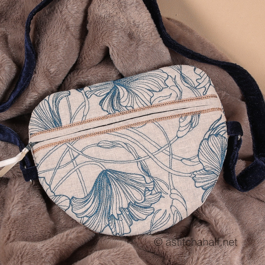 A completed zipper bag with a floral design, predominantly in blue and beige colors, laid on a soft, textured surface.