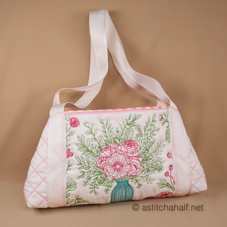 Embroidery pattern of a blue vase with pink flowers and green leaves on a white background.