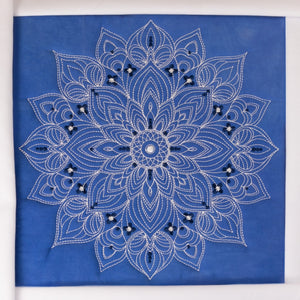 Decorative fabric with a white mandala design on a blue background