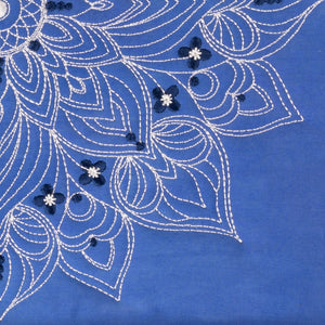 Embroidered floral design on a blue fabric background