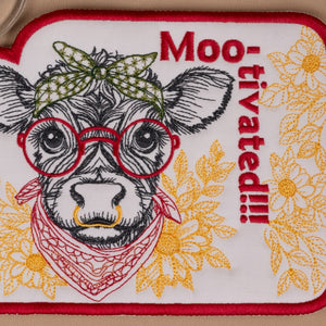 Embroidered patch with a cow wearing glasses and bandana, text 'Moo-tivated!!', and floral patterns.