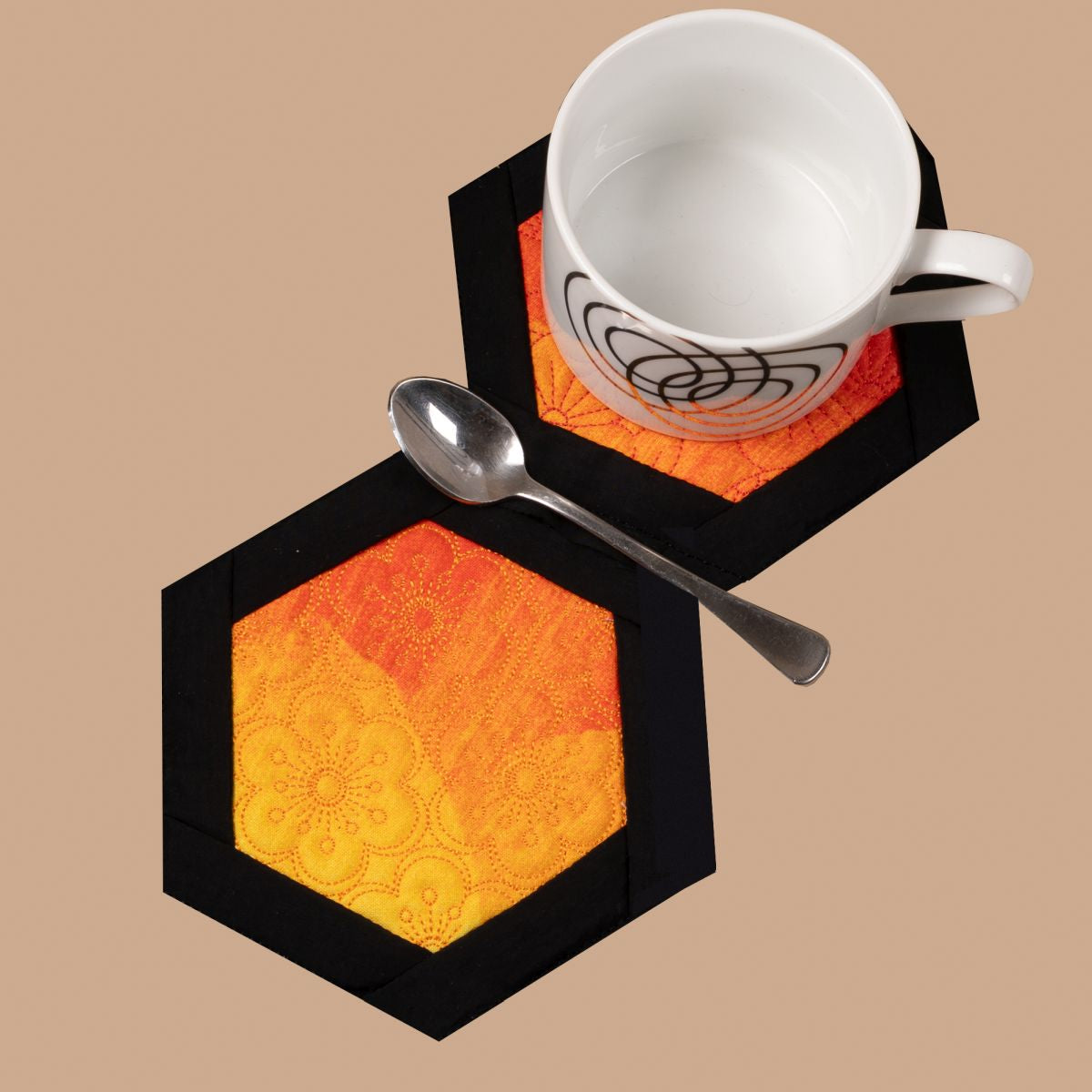 Hexagonal coasters with a cup, spoon, and mug on a beige background