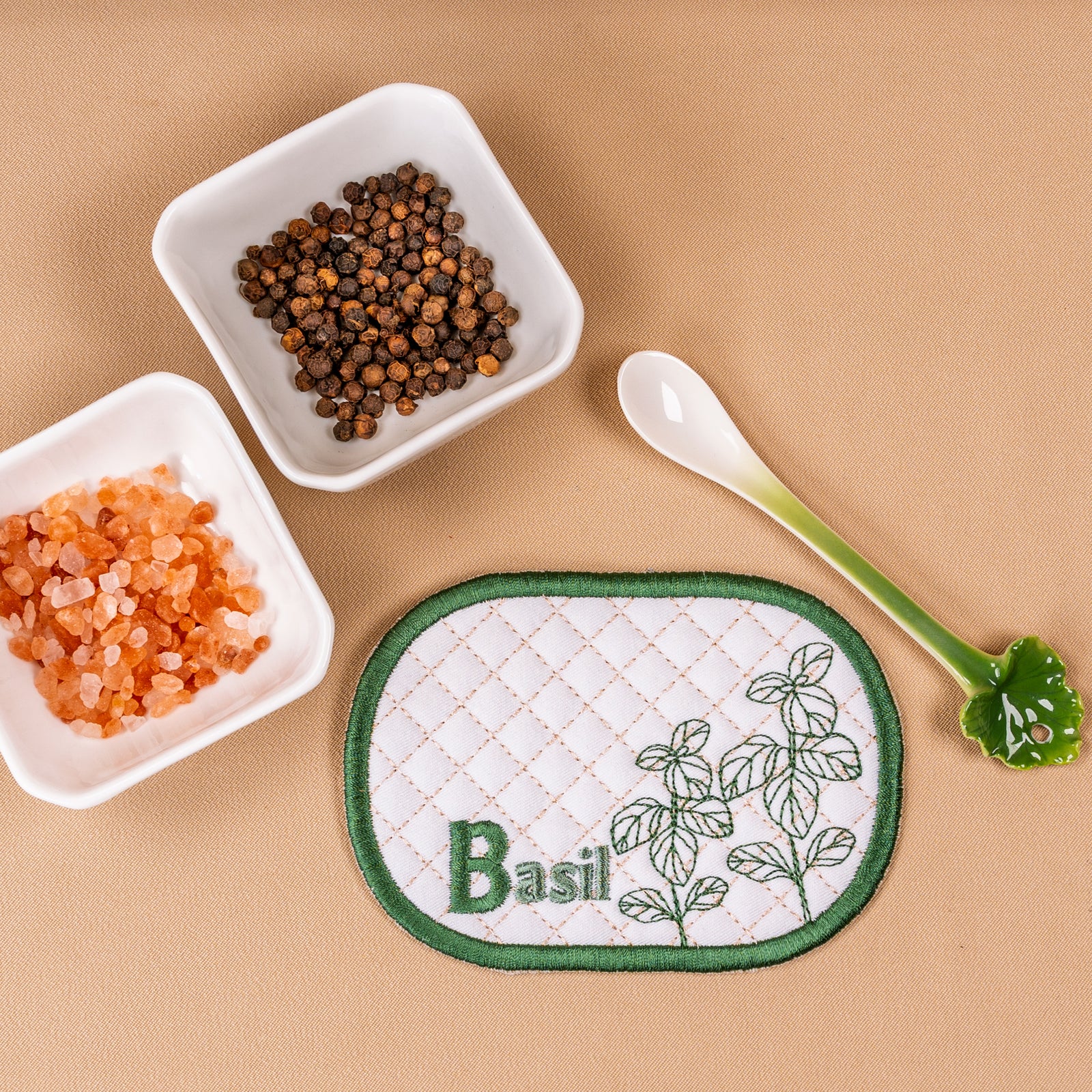 Set of herb-themed coasters on a beige background with small containers of spices.