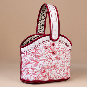 Handbag with floral embroidery on a beige background