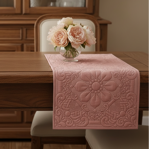 Pink floral-patterned table runner on a wooden table with a vase of flowers in a dining room setting.