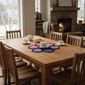 Hexagonal coasters with pink and blue design holding a white cup and saucer on a beige background