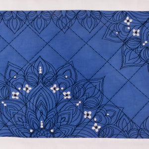 Blue fabric with floral embroidery and sequin embellishments on a white background