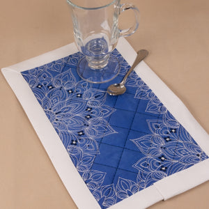 Blue and white patterned table runner with a glass and spoon on a beige surface
