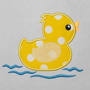 Yellow rubber duck with white spots on a light gray background
