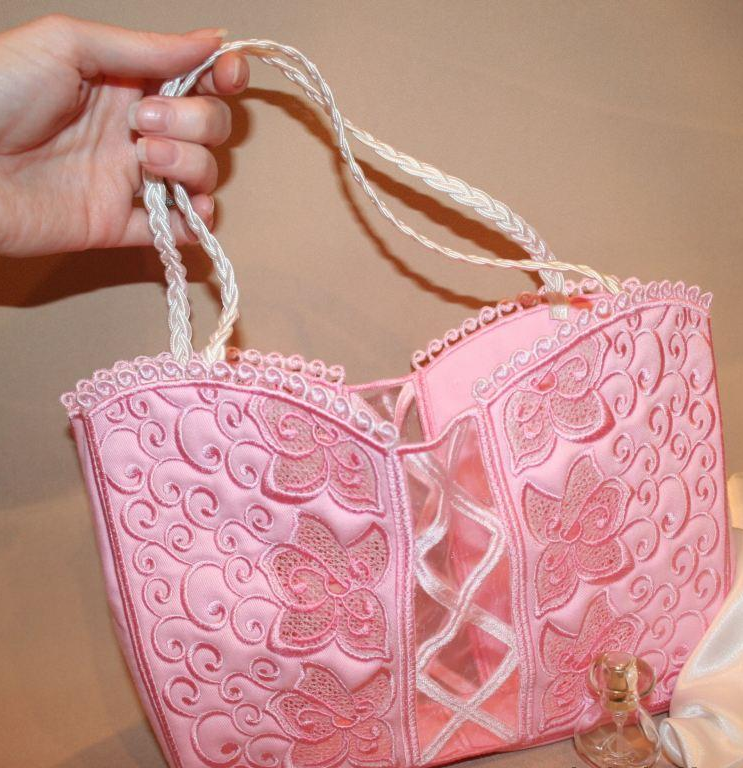 Pink lace handbag with matching accessories on a table