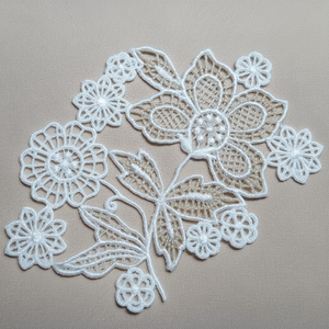 White lace flower design on a beige background