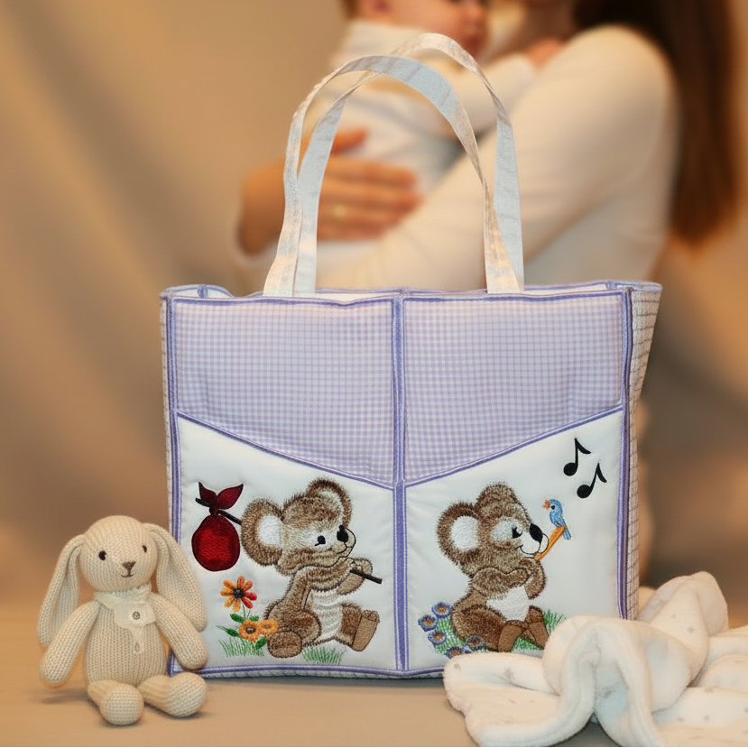 Baby bag with teddy bear design, woman holding a baby in the background