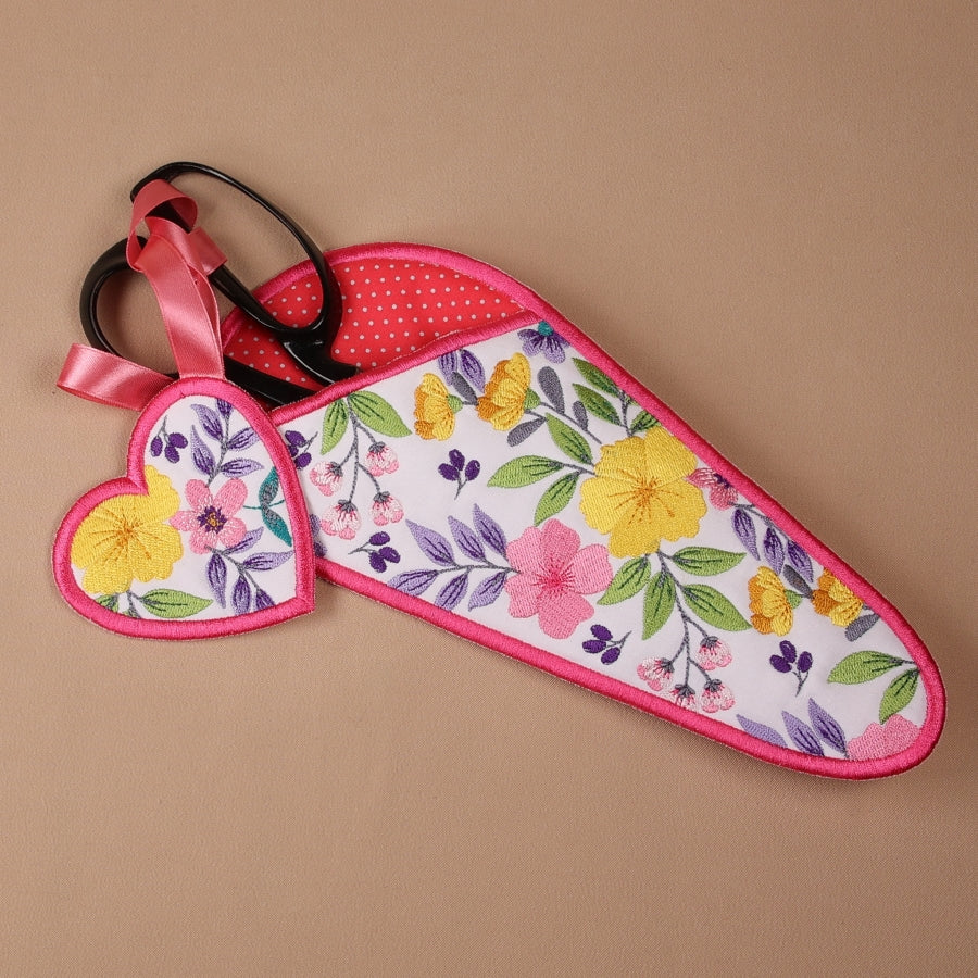 A floral fabric scissor case and fob set with a pink ribbon.