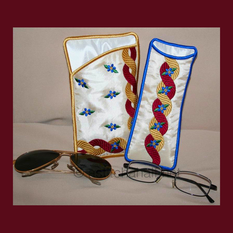 Royal Eyeglass Cases 05 - aStitch aHalf. Two embroidered eyeglass cases with decorative braided trim patterns in red and gold, along with small blue flowers - one with gold binding and one with blue binding.