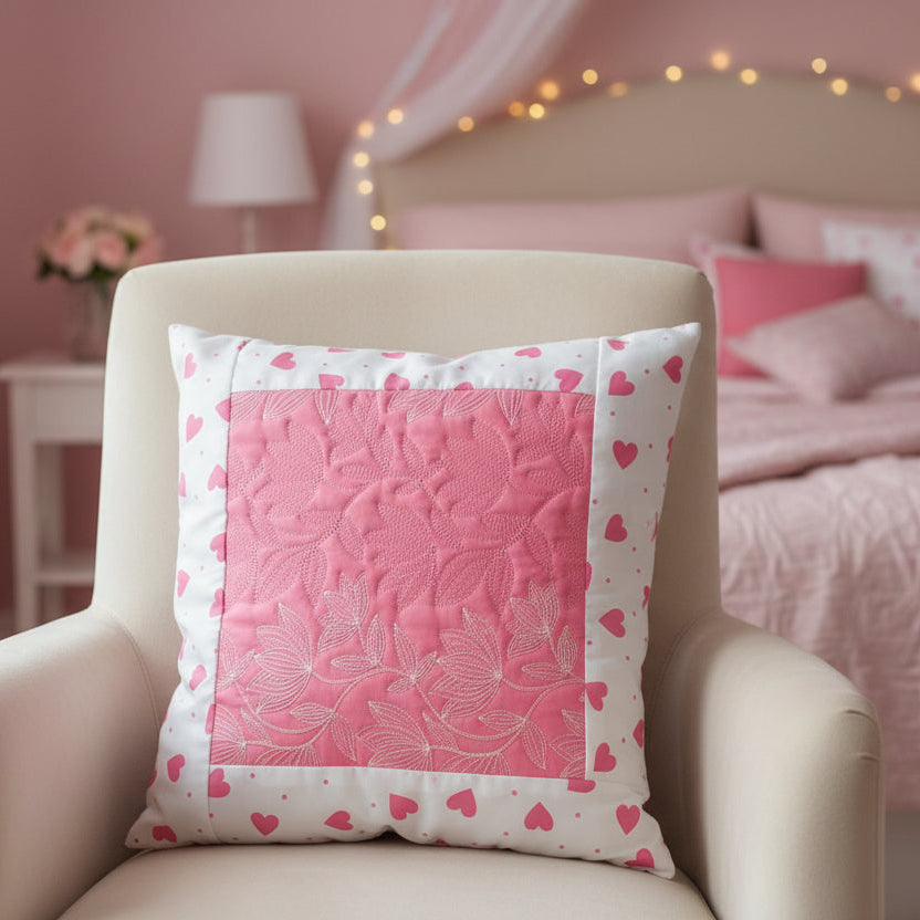 Pink pillow with heart patterns on a beige armchair in a bedroom setting.