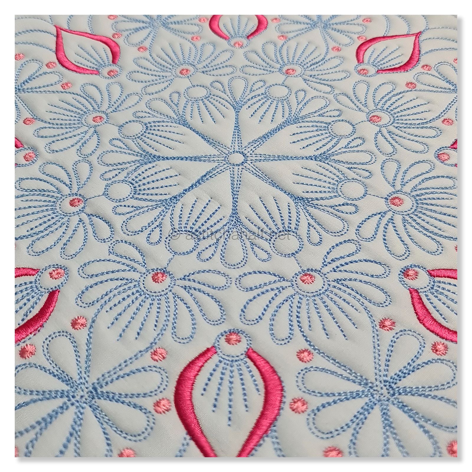 Embroidered design with pink and blue patterns on a light gray background