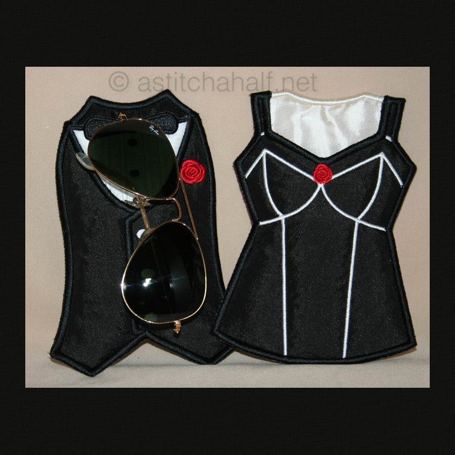 A pair of eyeglass cases designed to look like a man's and woman's shirt, embroidered in black with white outlines and red accents, displayed with sunglasses for scale.