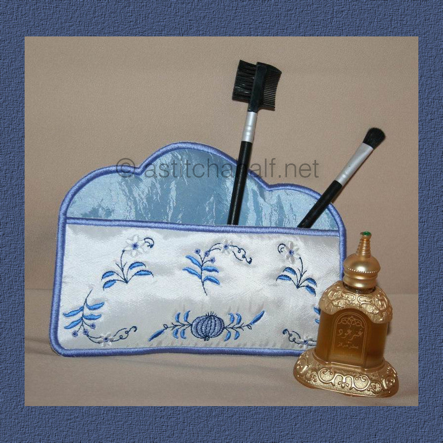 Blue Onion Cosmetic Bag - a-stitch-a-half. An embroidered makeup or toiletry bag with blue floral designs on white fabric and a blue marbled pattern on top, containing makeup brushes. 