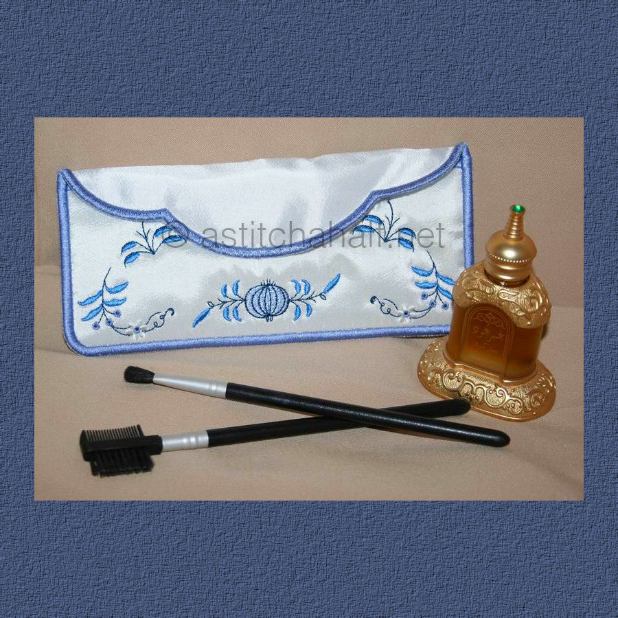 Blue Onion Cosmetic Bag - a-stitch-a-half. An embroidered makeup or toiletry bag with blue floral designs on white fabric and a blue marbled pattern on top, containing makeup brushes. 